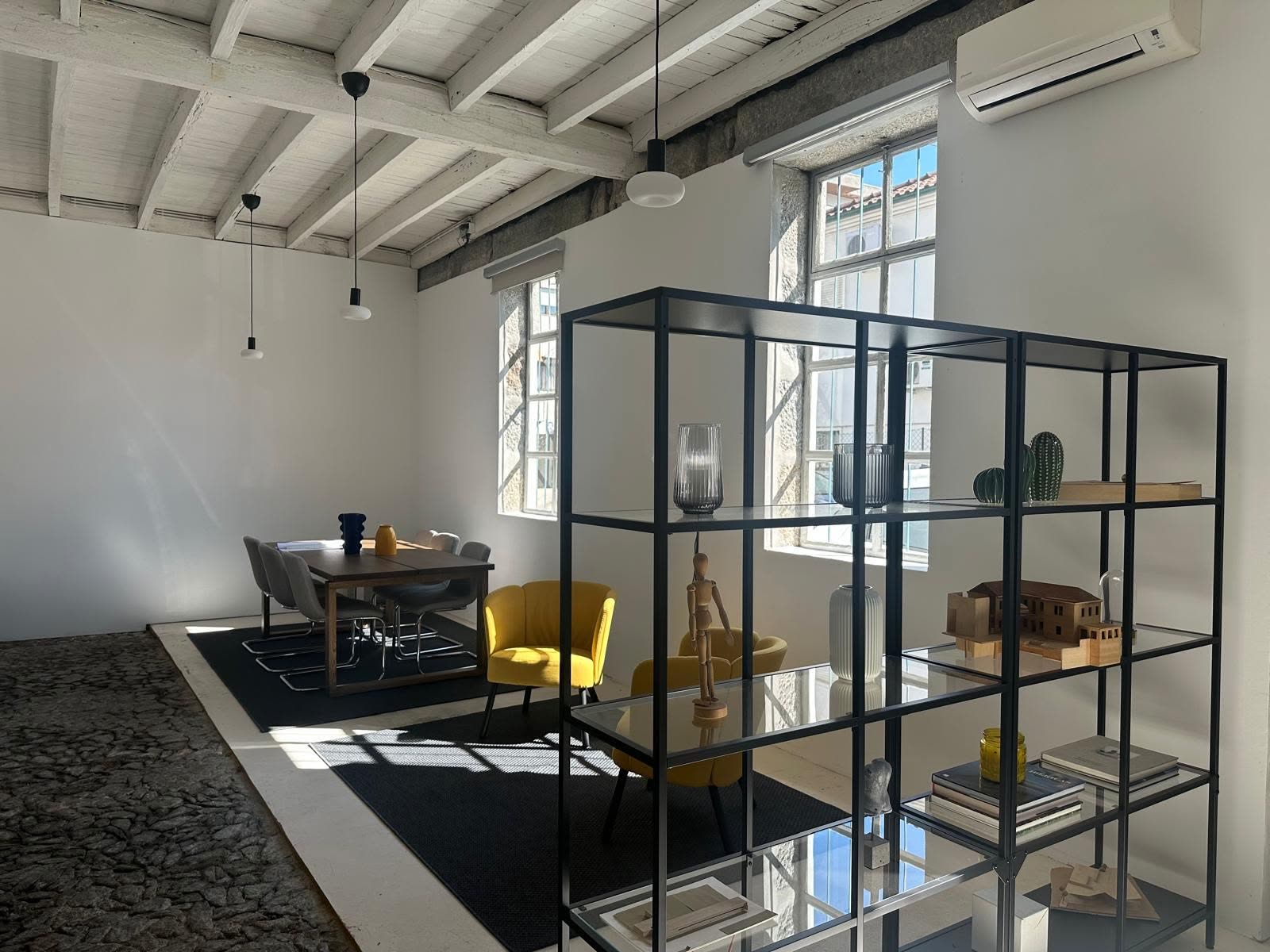 Interior do novo atelier, com estantes metálicas e mesa de trabalho