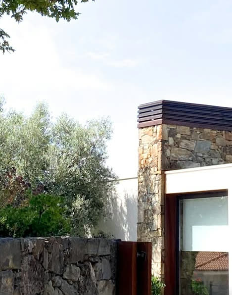 Entrada com muro de pedra e volume branco