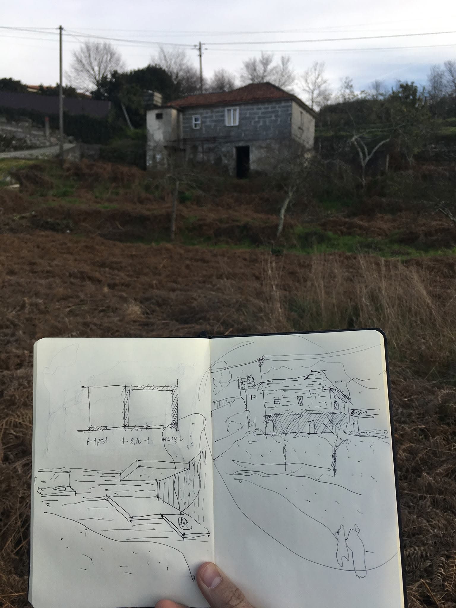 Caderno de esquissos aberto em frente a uma ruína